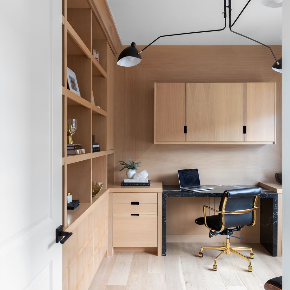 家庭办公室内衬天花板到地板的木架子和配套的硬木地板