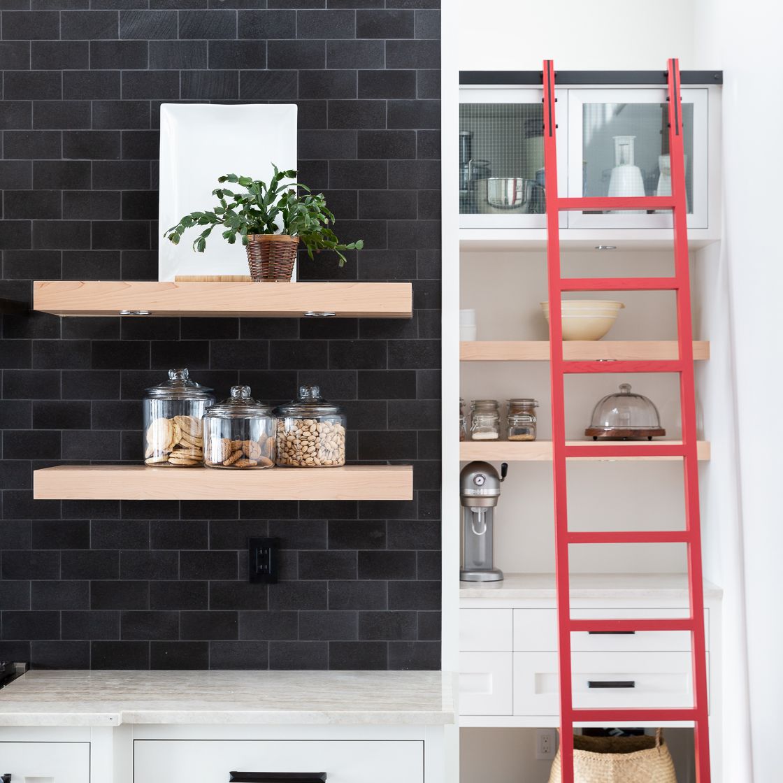 一个黑色和白色厨房，有一个大胆的红色口音梯