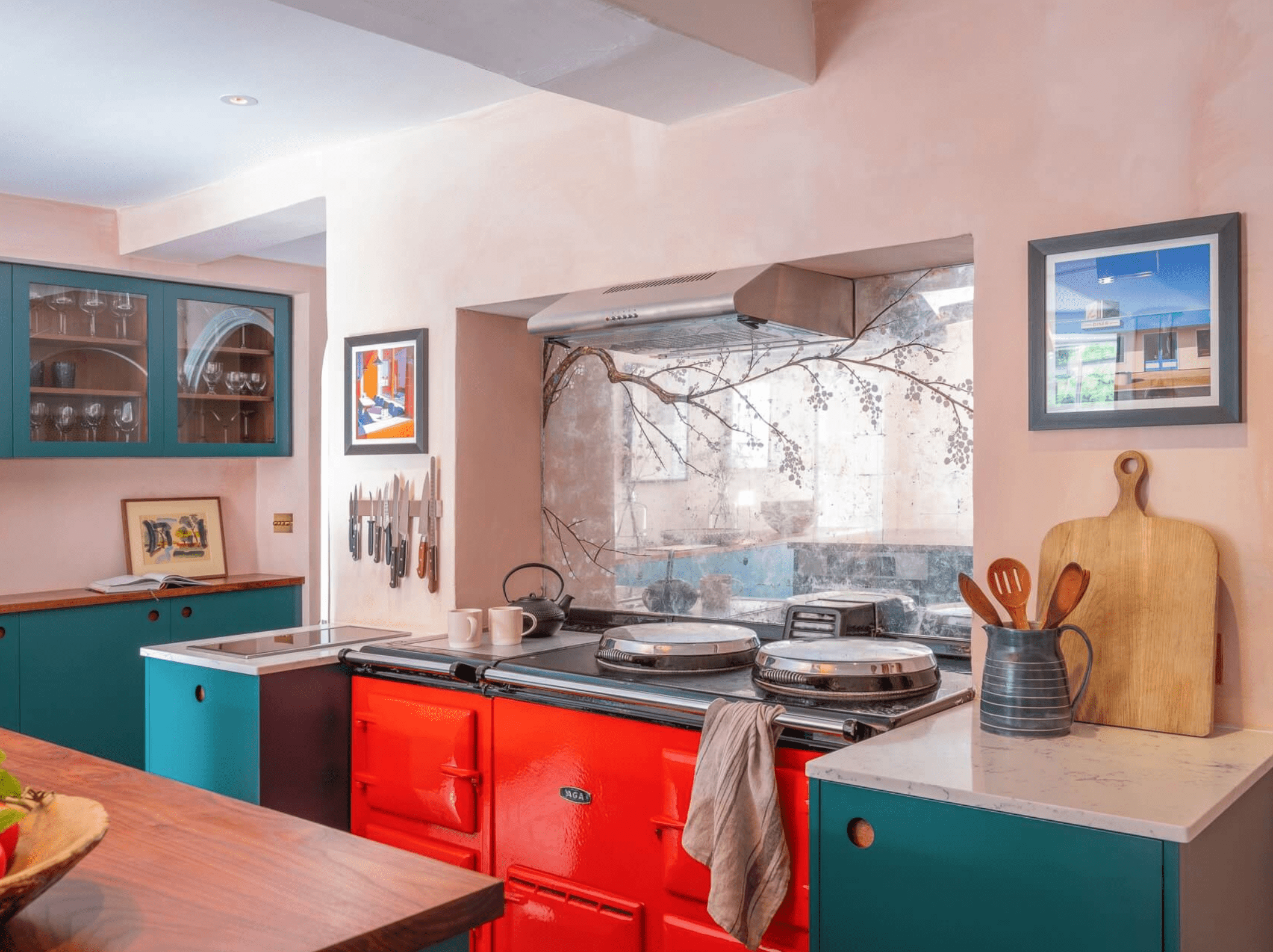 带粉红色墙壁和蓝绿色橱柜的厨房