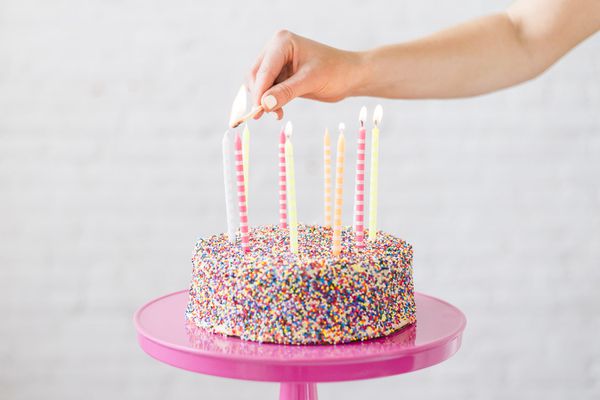 在生日蛋糕上点燃蜡烛的女人