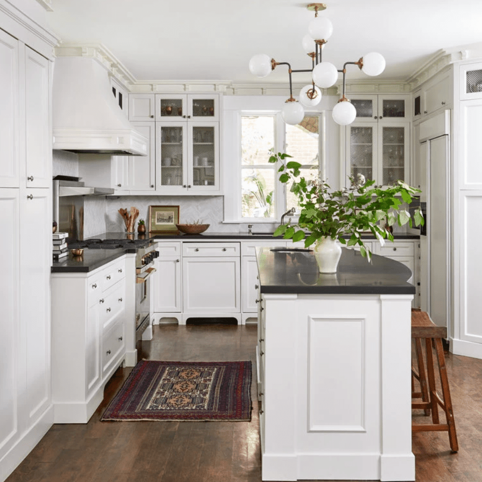 一个中间的现代厨房，粗体灯具和深红色的地毯