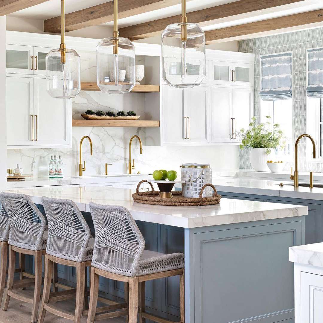 别致用尘土飞扬的蓝色海岛和大理石台面的沿海厨房。