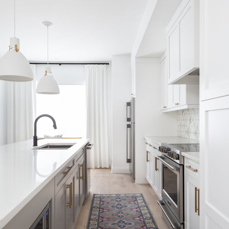 一个小型的白色厨房装饰着印花厨房跑步者地毯