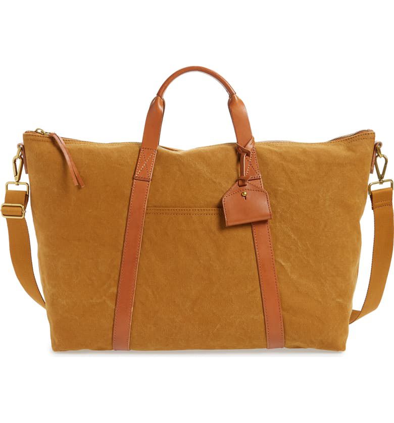 一个棕色帆布行李袋与皮革处理和细节和横体带。