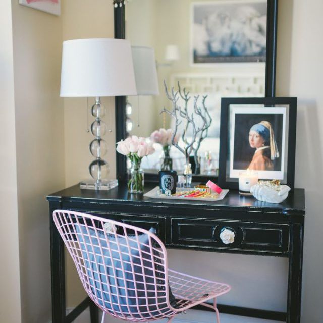 黑色梳妆台用乐趣粉红色的椅子和装饰。