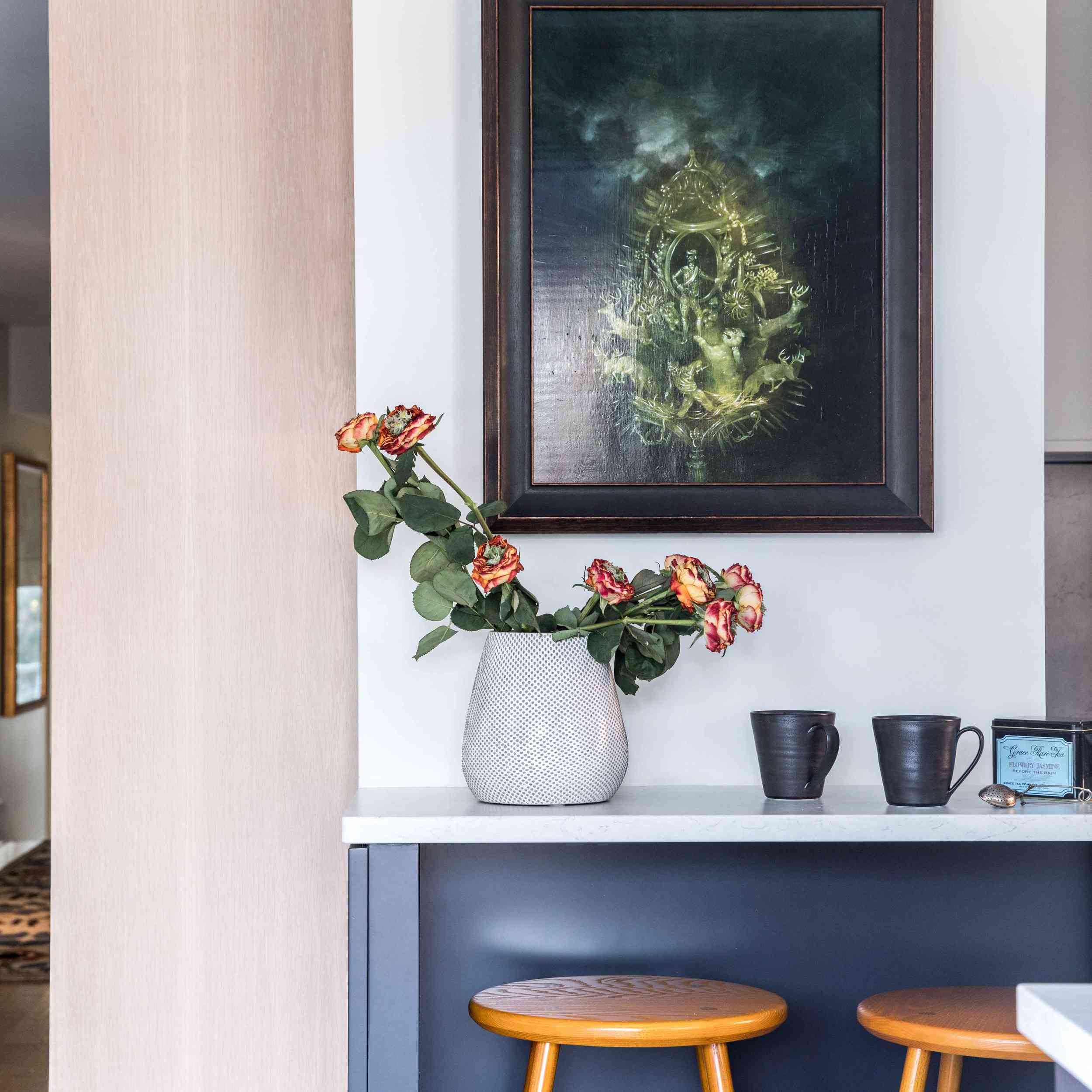 一间有画、花和几张木凳的乡村厨房