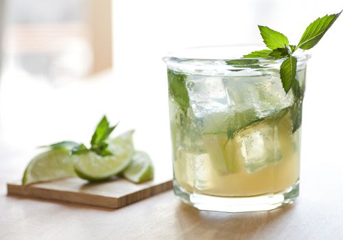 伏特加cocktail in a glass with mint and lime garnish.“class=