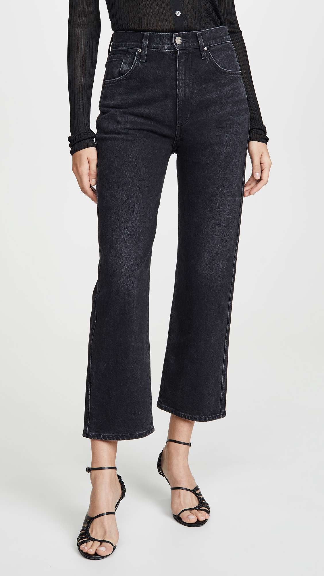 一个女人造型一双黑色的，高腰，裁剪牛仔裤