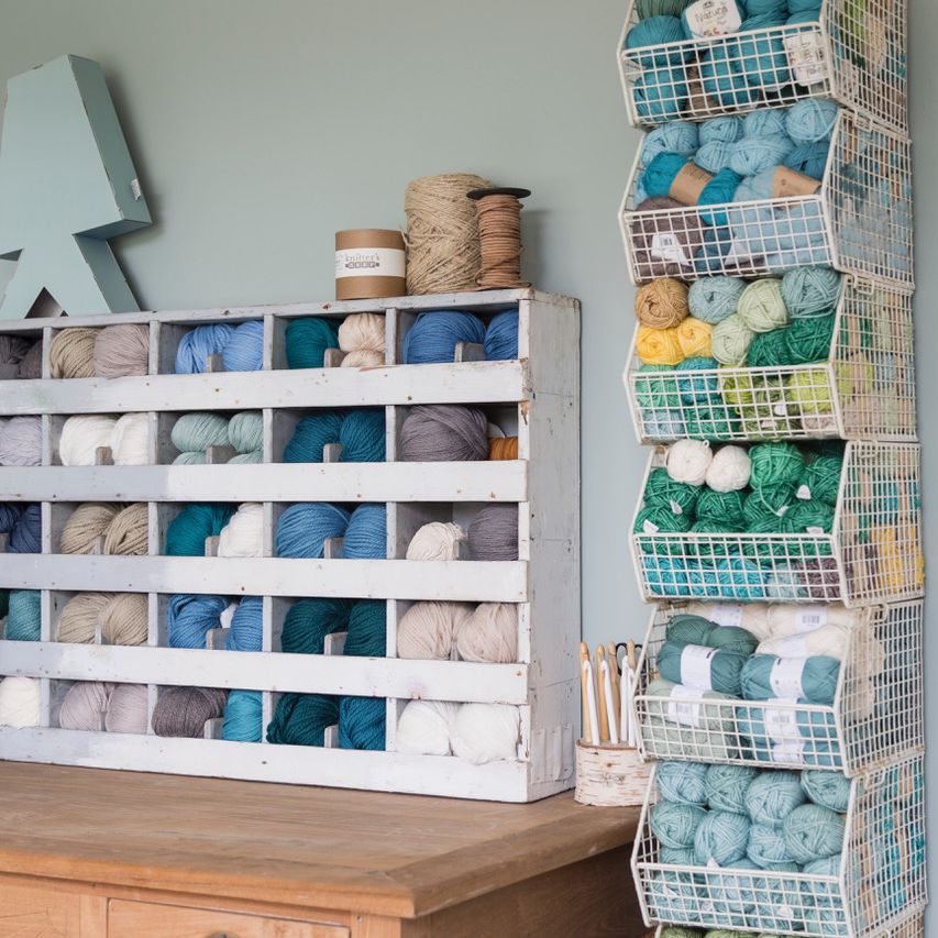 一间颜色协调的工艺室，里面摆满了蓝色和中性色的纱线