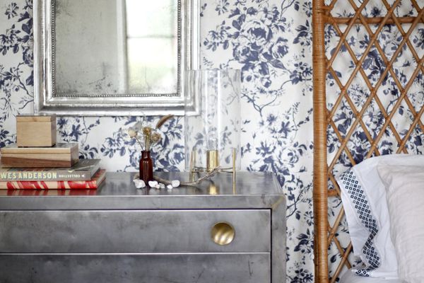 卧室里有蓝白两色的壁纸，灰色的梳妆台和柳条床架