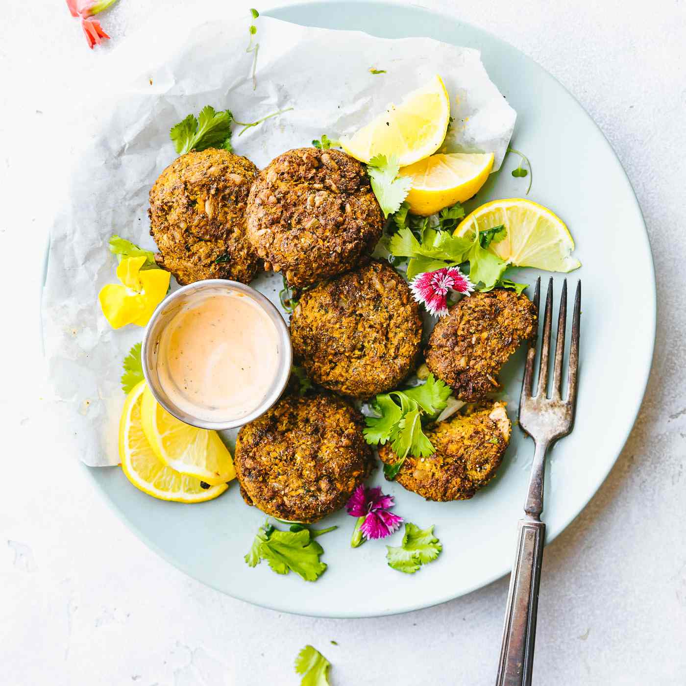 蔬菜肉饼与柠檬片和酱汁放在盘子里
