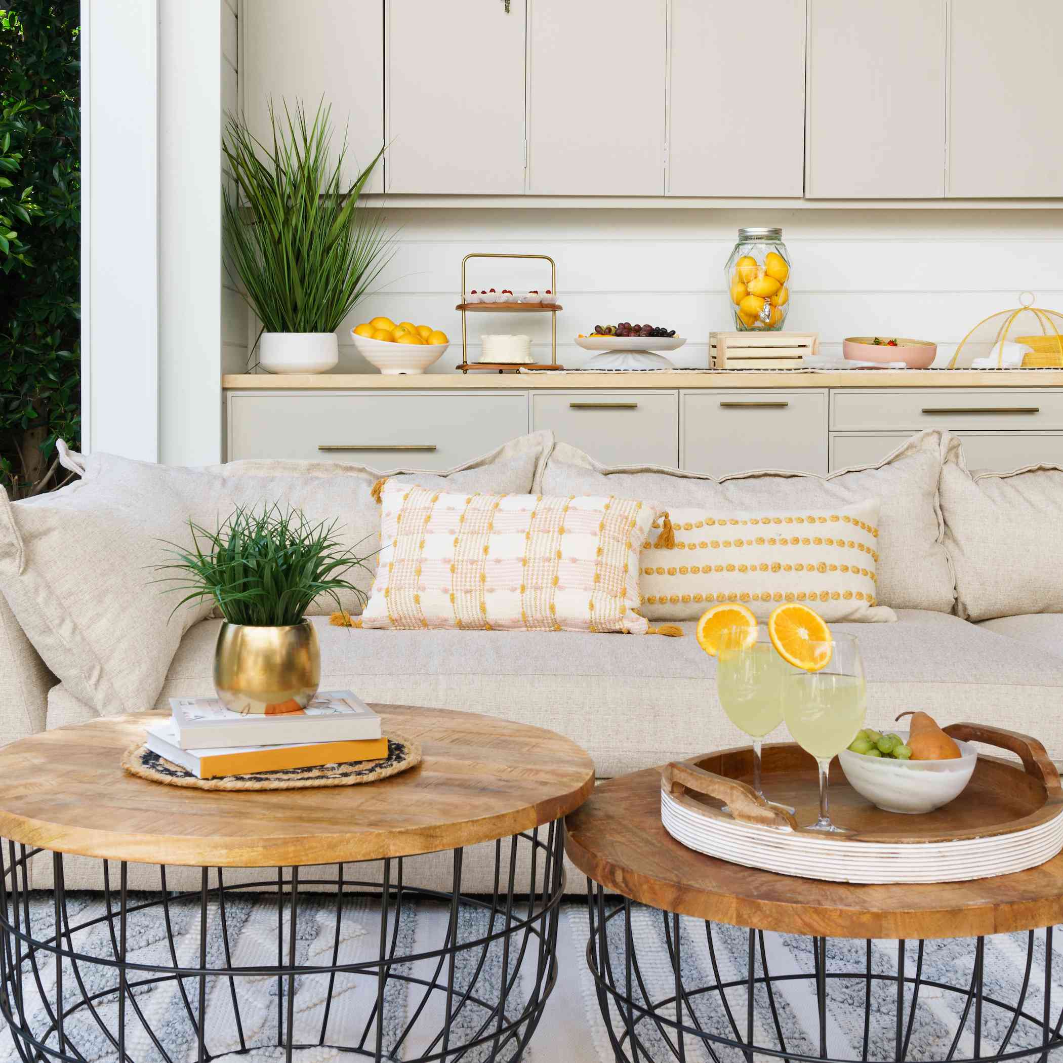 户外空间用米色长沙发和两张木咖啡桌。