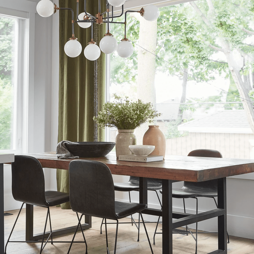 桌上摆着花瓶、碗和一本书的木制餐桌