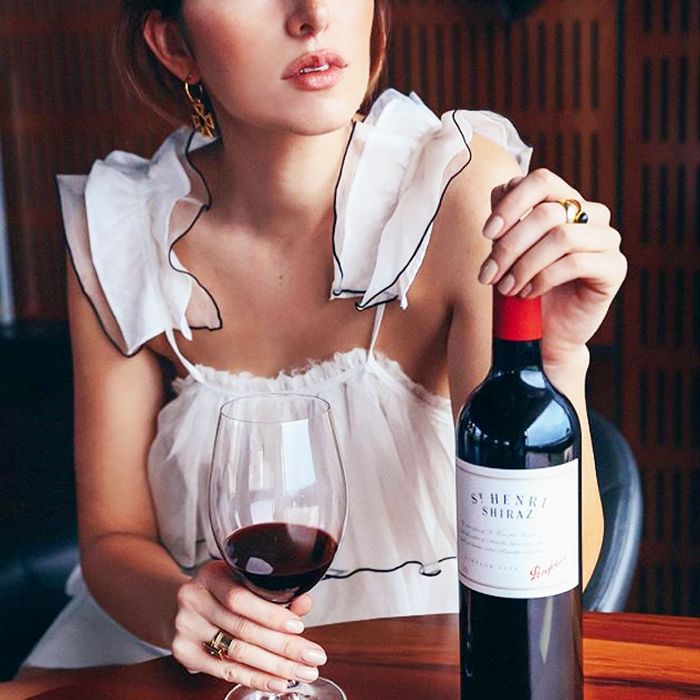 一个女人拿着酒杯和酒瓶的剪裁过的图像