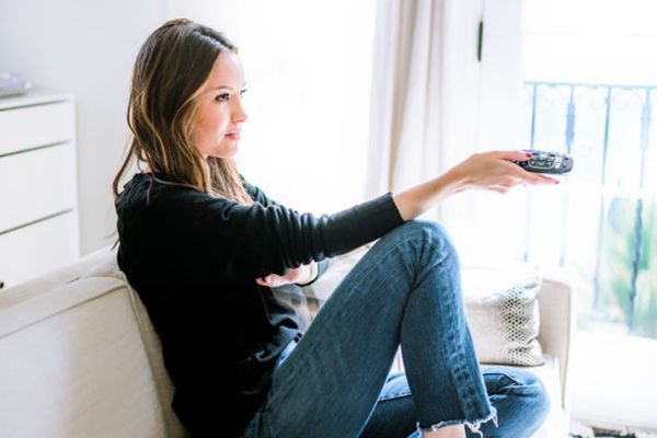 一个拿着电视遥控器的女人