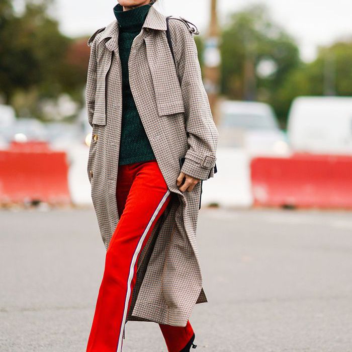 穿着风衣、亮色裤子和装饰高跟鞋的女人