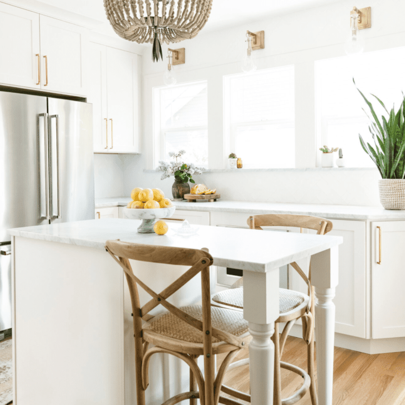 一个带有岛屿的一个小型白色厨房，被转换成一个小型餐厅