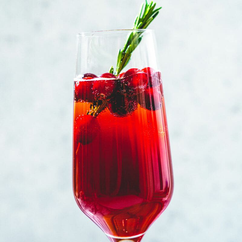 用香槟酒笛和迷迭香点缀的香槟鸡尾酒。