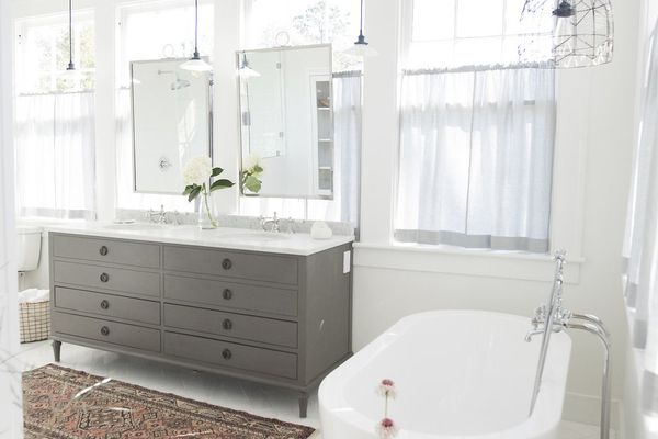 白色和干净的浴室，浴缸和凳子。