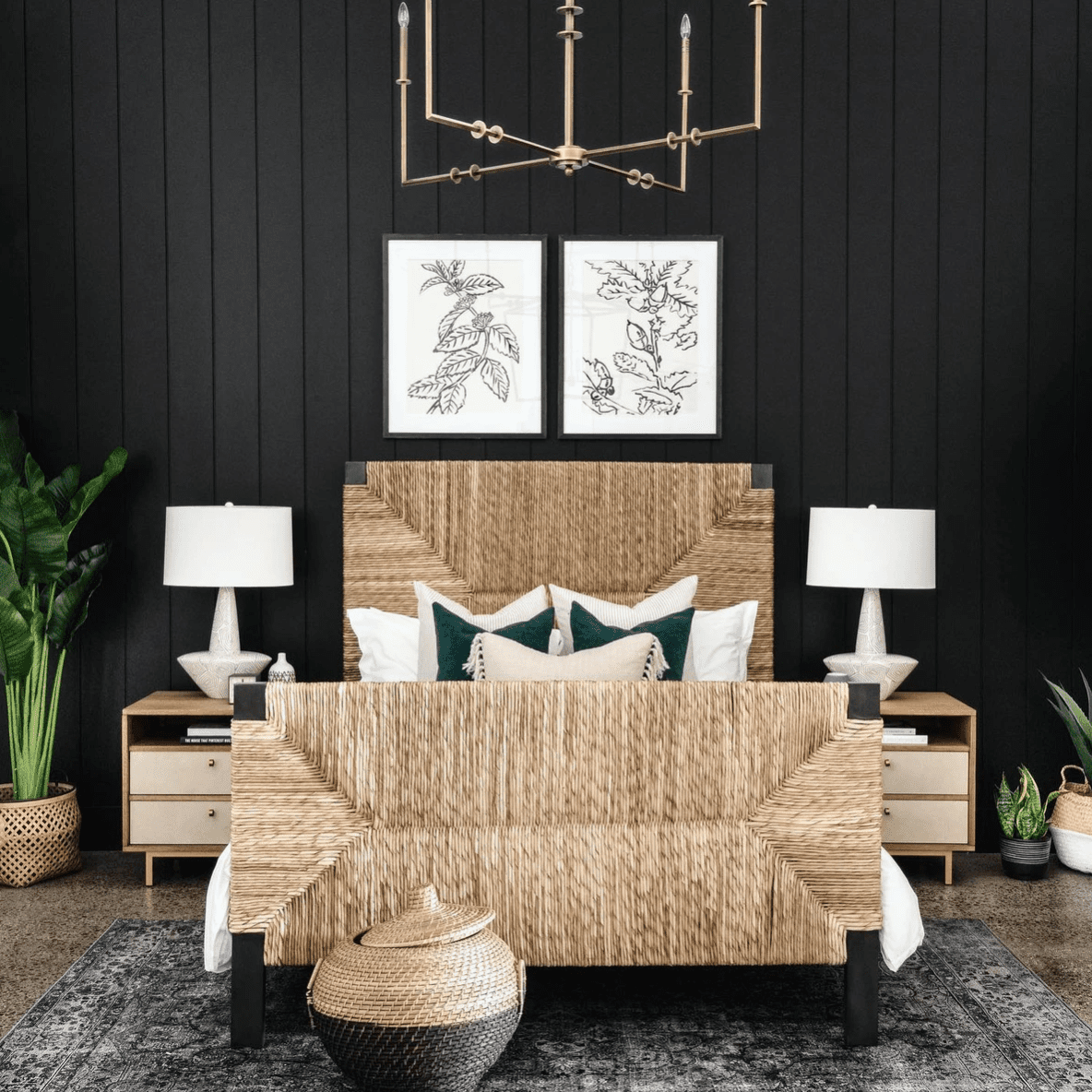 一个黑色卧室，有两个粗体桌灯和角枝形吊灯