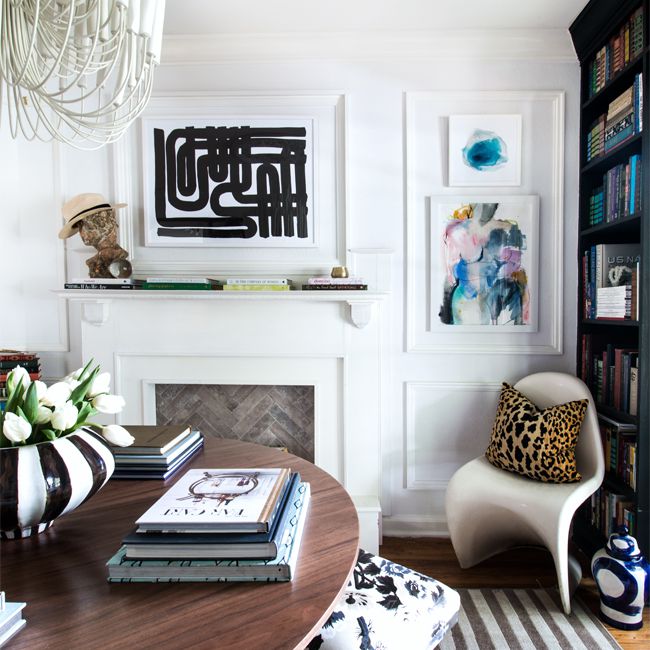 白色客厅，框架艺术品和一个大的白色吊灯。