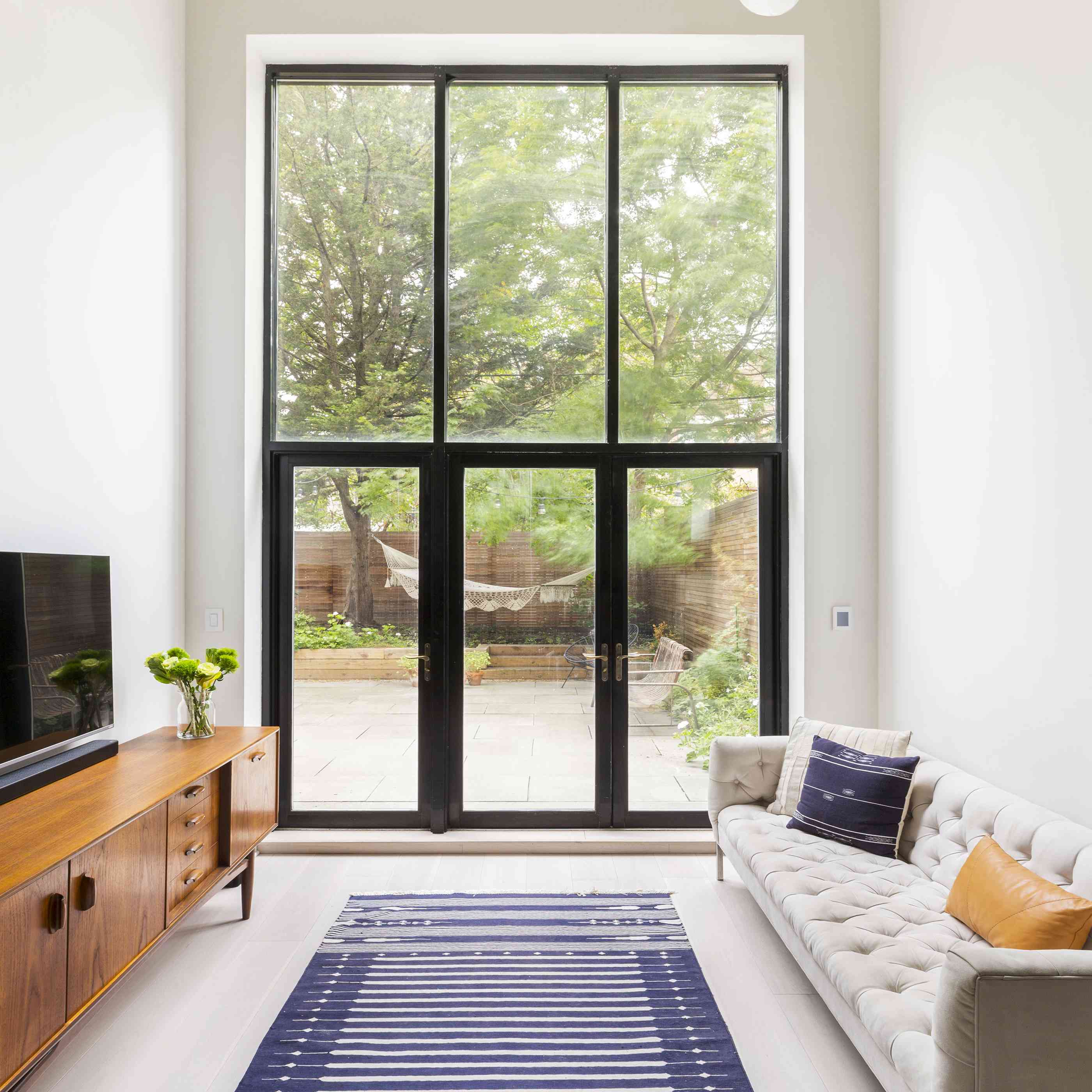 现代客厅配有吊坠照明和大窗户。