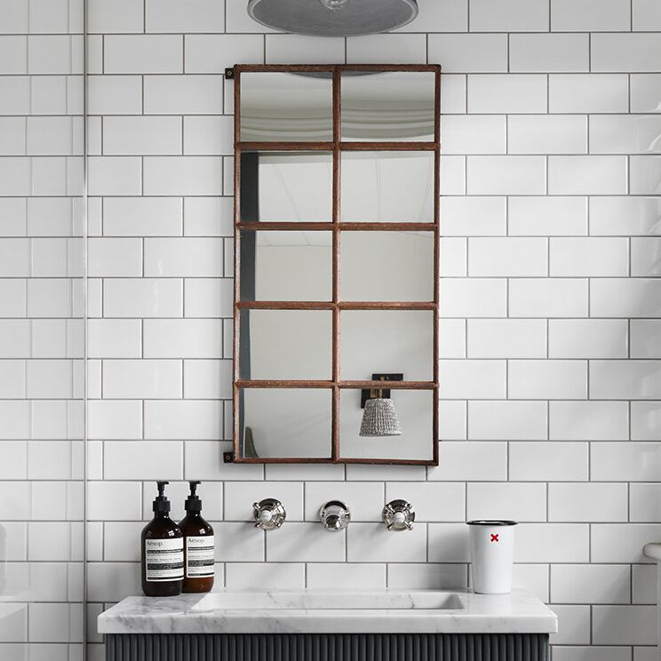 浴室配有白色地铁瓷砖和大胆的几何镜子