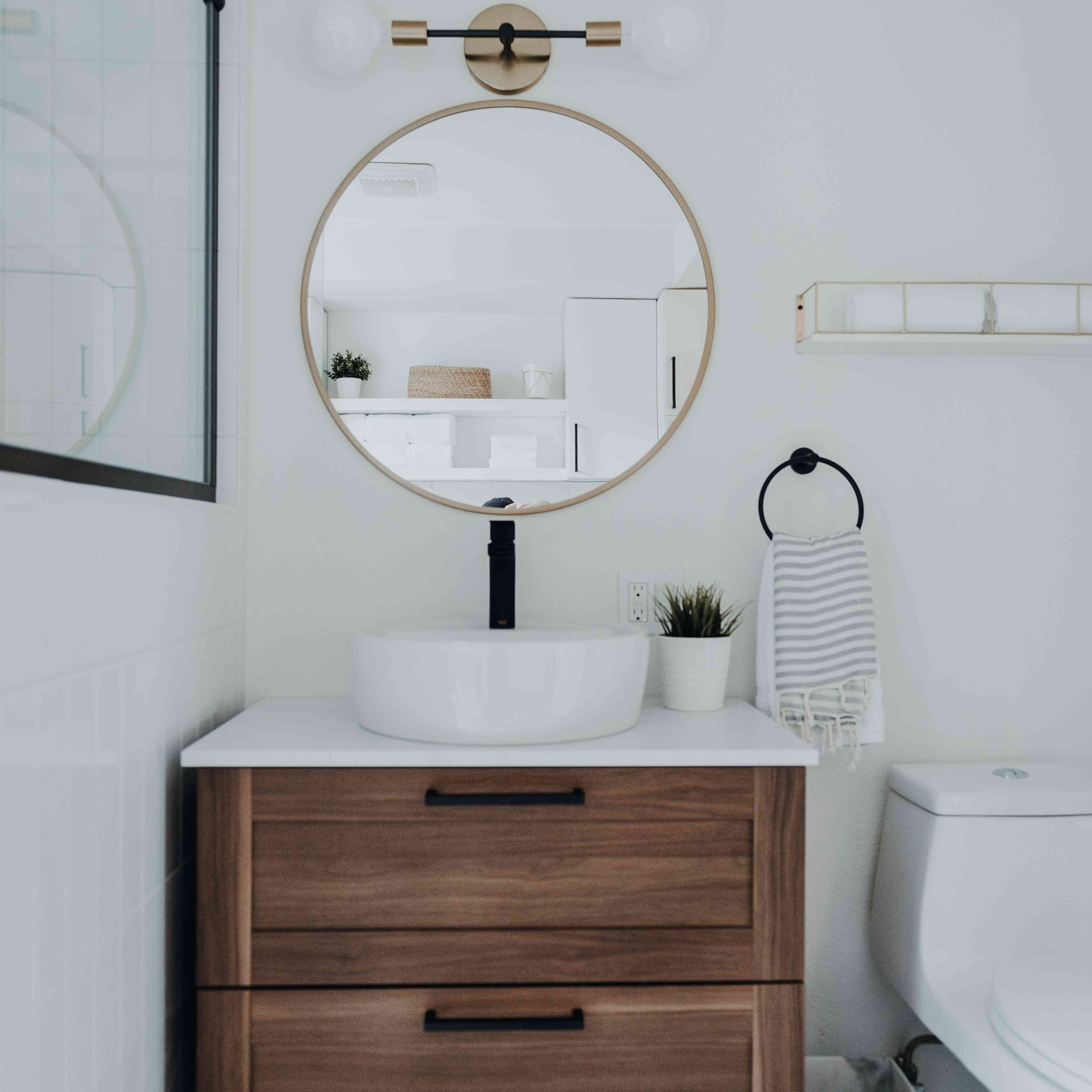 浴室配有瓷砖地板和金镜子