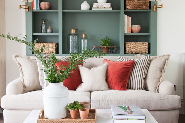 Green built-in bookshelves behind couch.