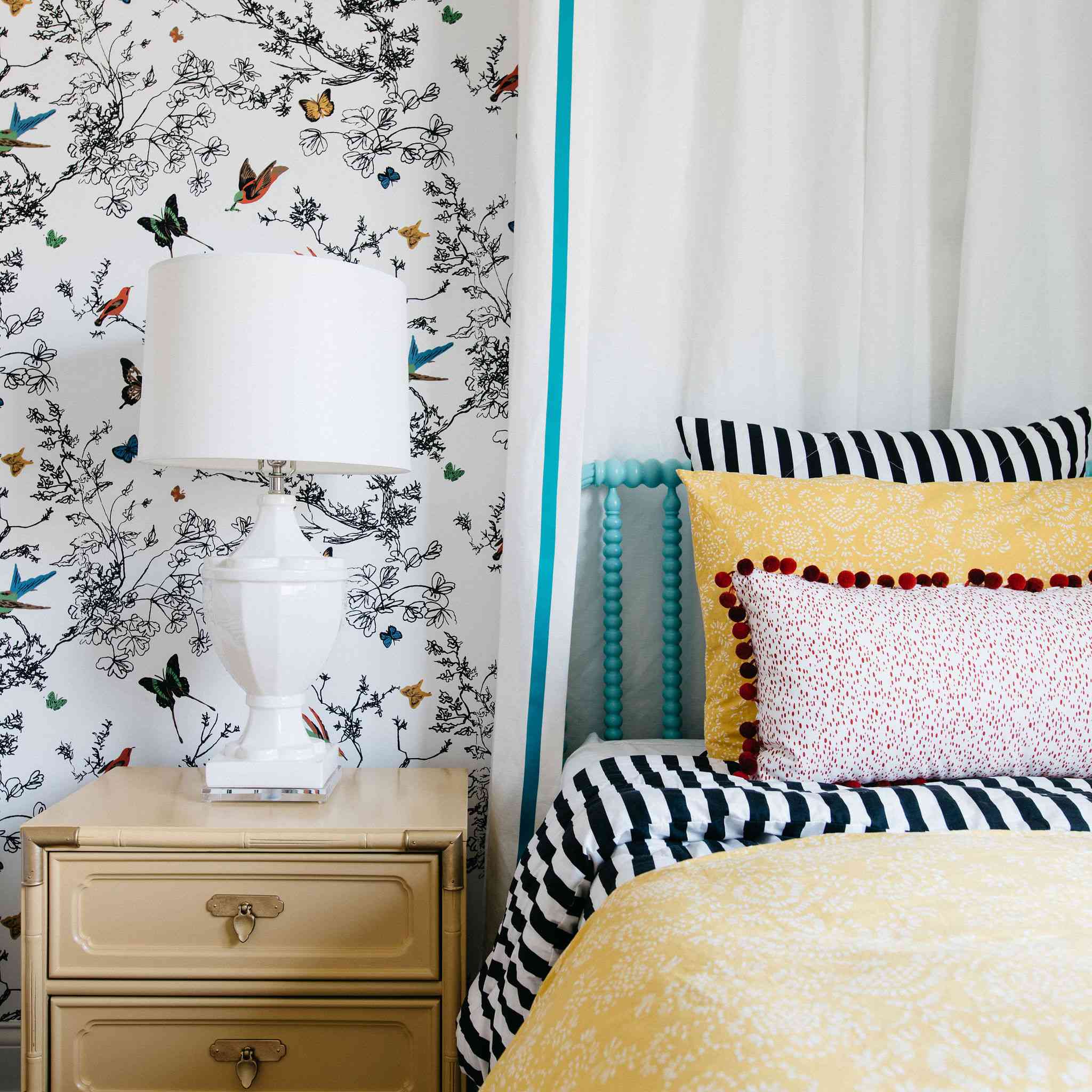 后拍摄的明亮的阳光黄色床上用品和图案墙纸的卧室。