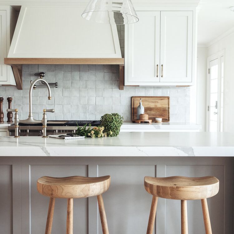 一个全白色的厨房，配有方形的白色背板瓷砖