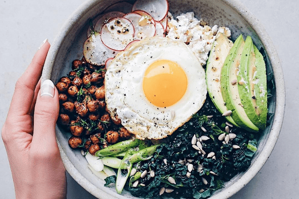 肠道健康的碗蔬菜，鳄梨和一个煎鸡蛋