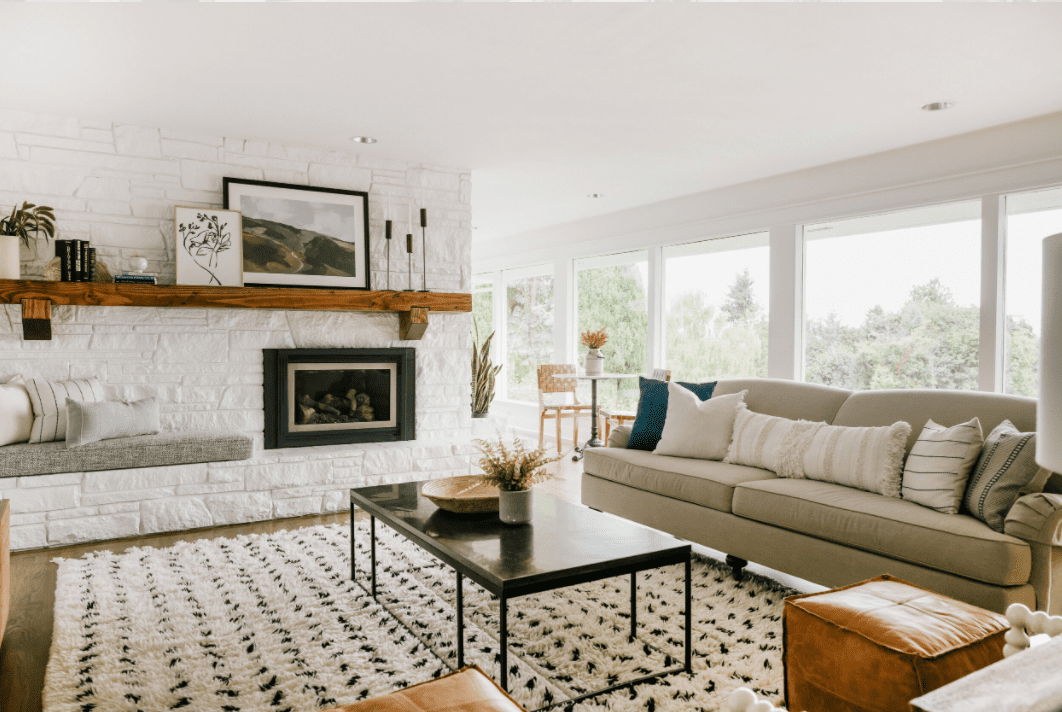 明亮的客厅与中性沙发和白色壁炉。