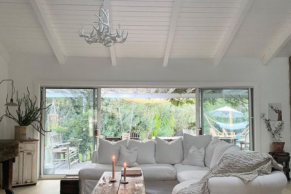 舒适的白色起居室，带纹理毯子和蜡烛点燃了。