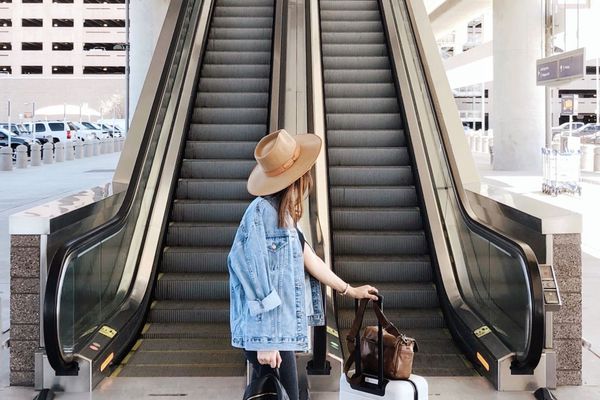 a woman with a suitcase arriving at the airport