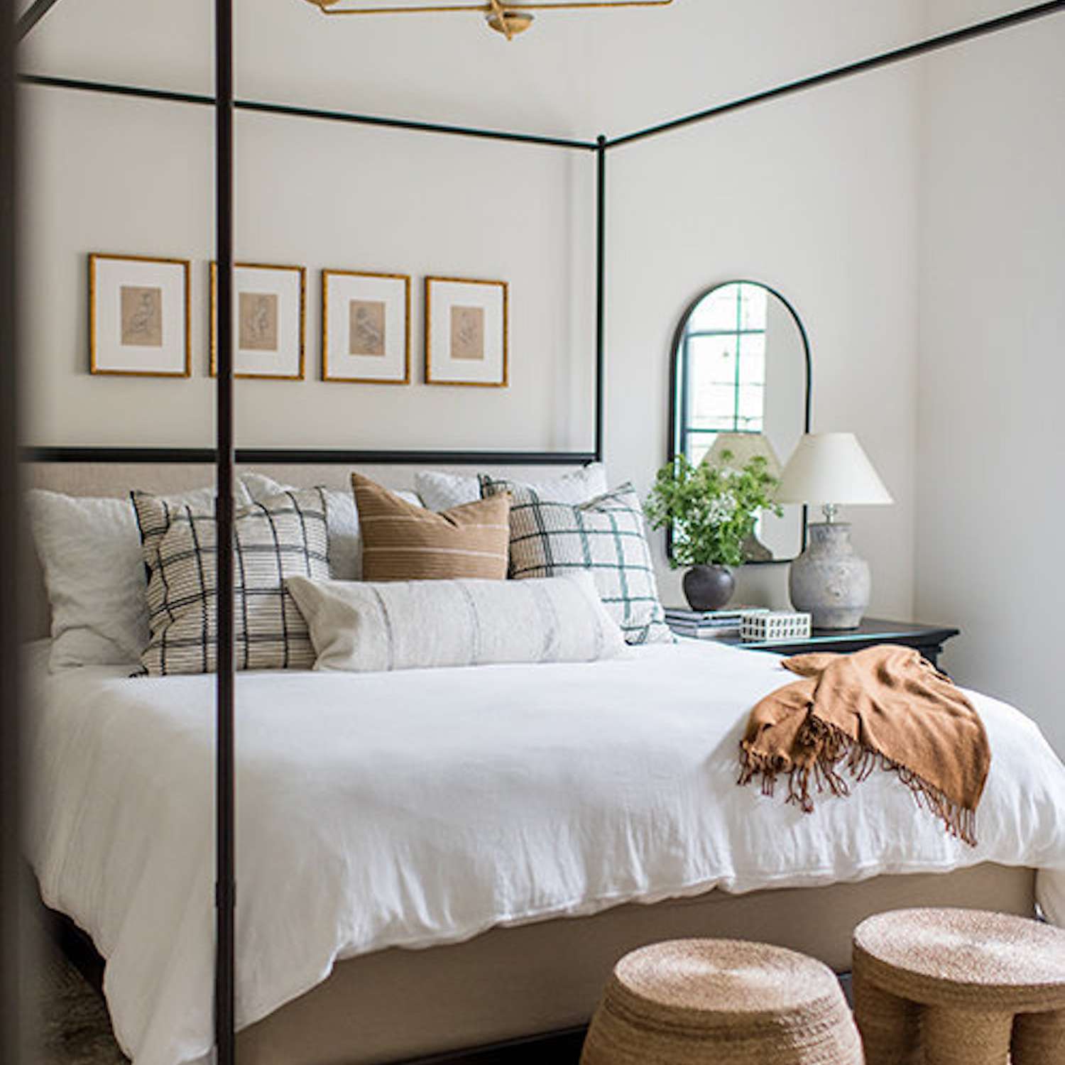 舒适的卧室配有天篷床和中性床上用品。