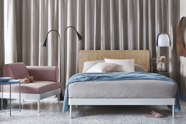 卧室有粉红色的椅子和藤条床头板