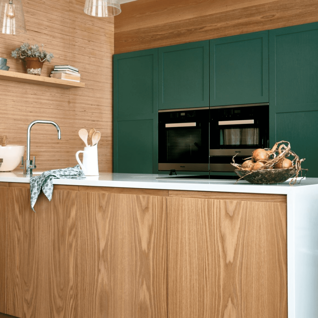 一个有绿色橱柜的木衬里厨房